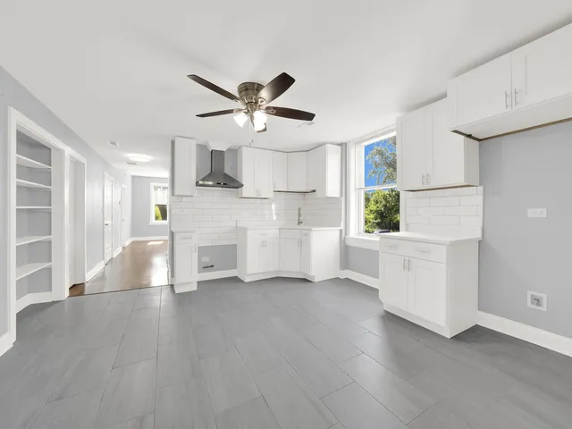 a view of a big yard with plants and a bench