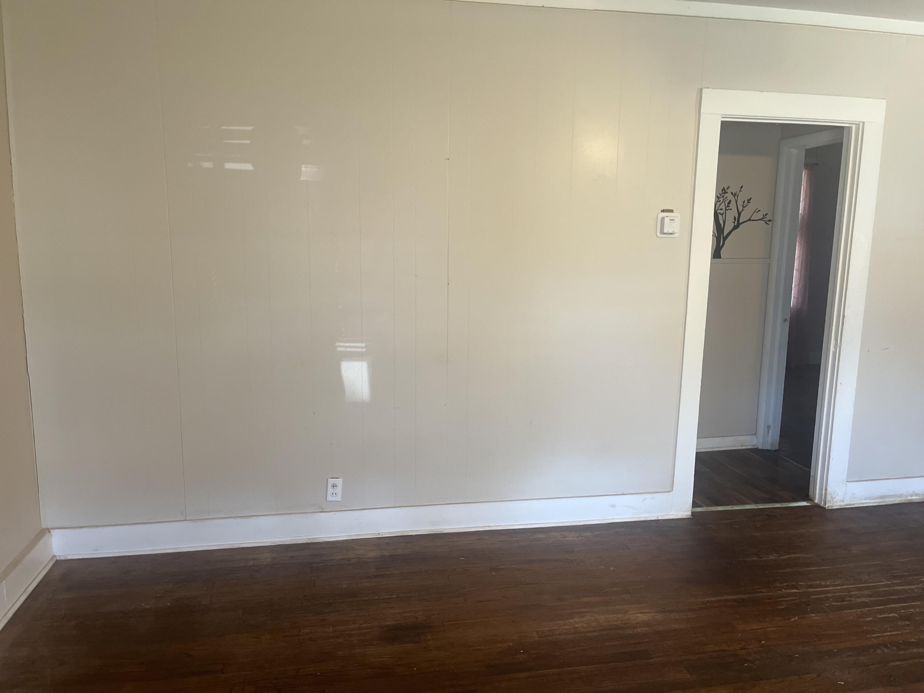 2206 26th Street Lubbock, TX 79411 - Photo 2 of 15 an empty room with wooden floor and door