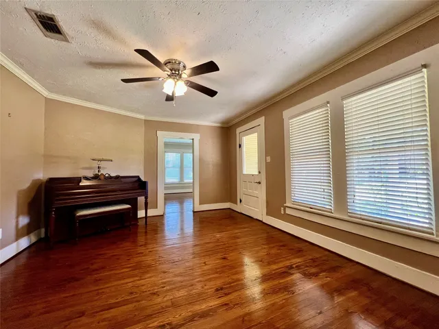 a room with wooden floors and a ceiling fan