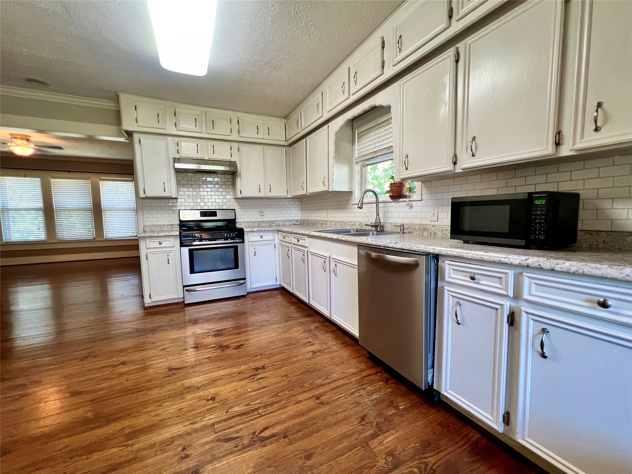 605 Keith Street Kennard, TX 75847 - Photo 6 of 14 a kitchen with stainless steel appliances granite countertop a stove a sink and a microwave