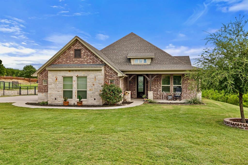 2103 Cash Point Court Granbury, TX 76049 - Photo 2 of 38 a front view of a house with a yard porch and outdoor seating