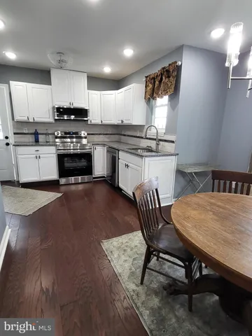 a kitchen with a table chairs microwave and cabinets