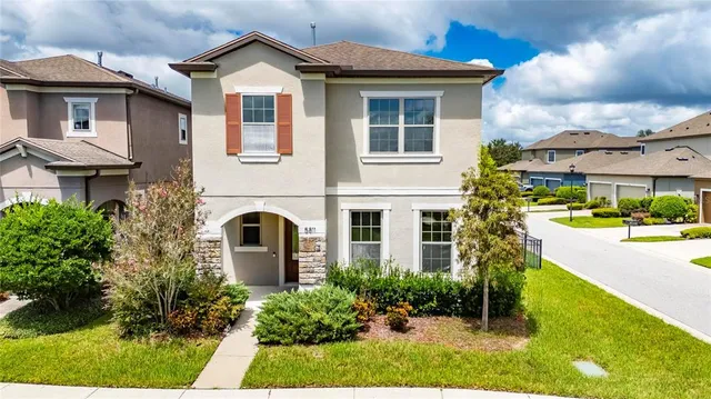 a front view of a house with a garden and plants