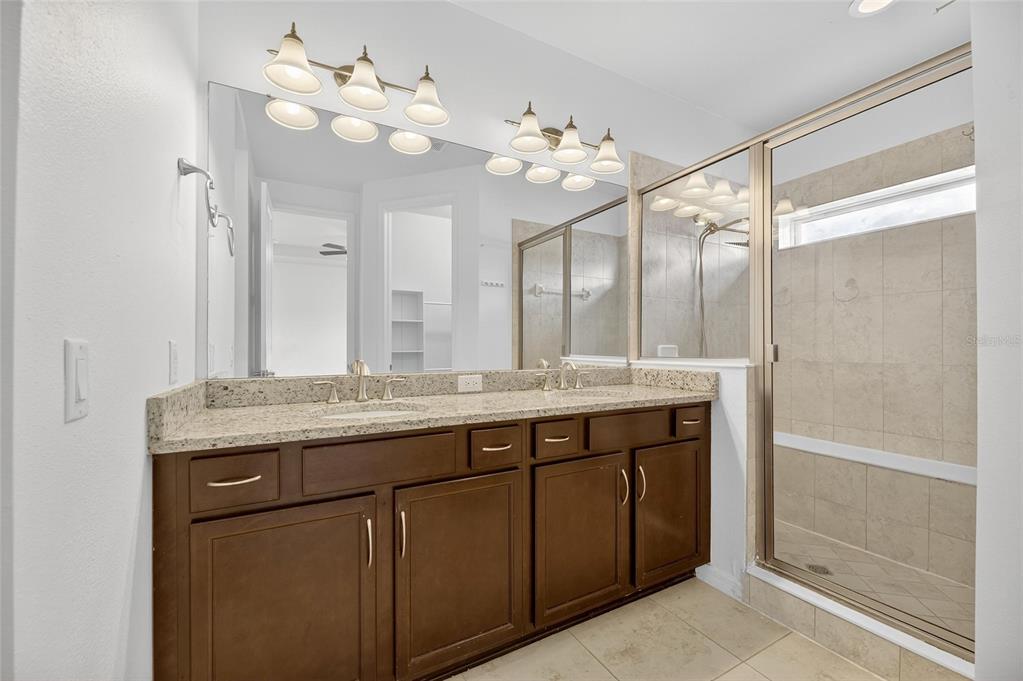 5811 Caldera Ridge Drive Lithia, FL 33547 - Photo 21 of 44 a bathroom with a granite countertop sink a large mirror and a shower