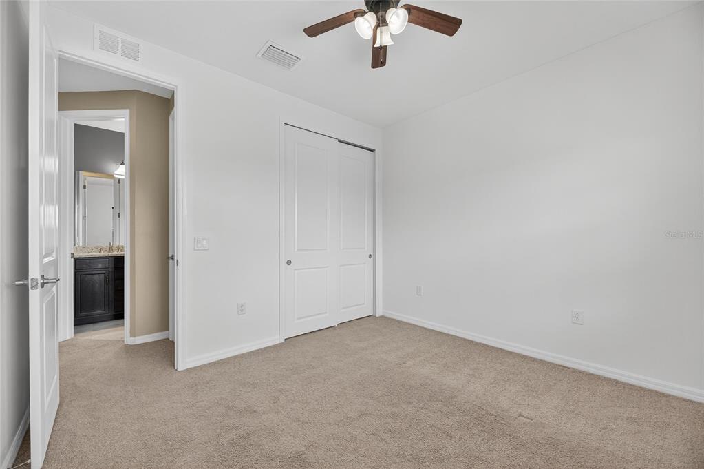 5811 Caldera Ridge Drive Lithia, FL 33547 - Photo 22 of 44 an empty room with a chandelier fan and windows