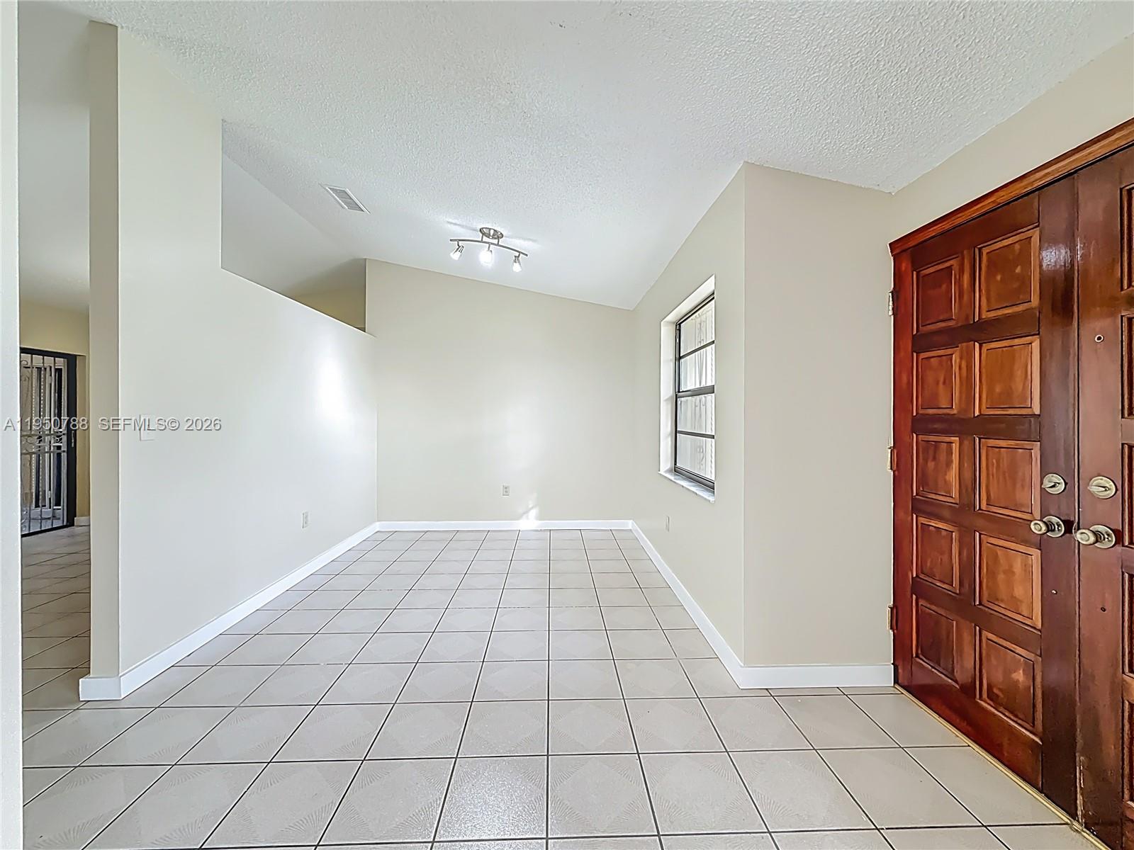 12787 Northwest 10th Lane Miami, FL 33182 - Photo 11 of 48 a view of an empty room and entryway with a window
