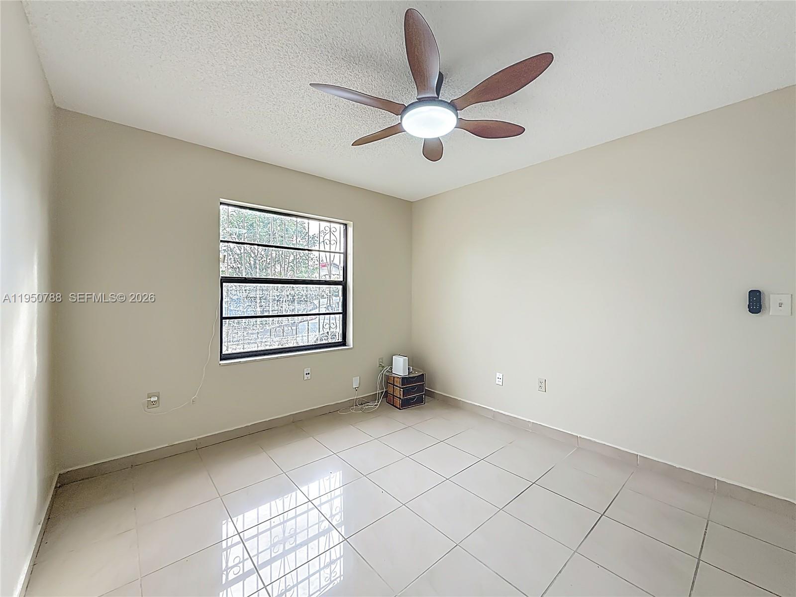 12787 Northwest 10th Lane Miami, FL 33182 - Photo 27 of 48 an empty room with windows and fan