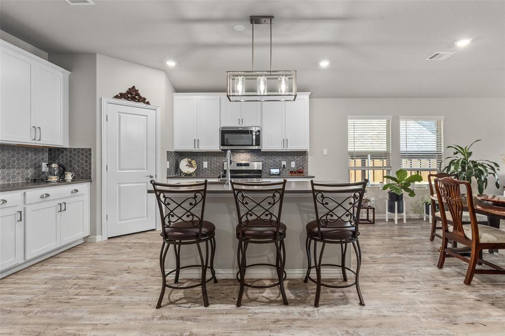10505 Trail Ridge Drive Fort Worth, TX 76126 - Photo 4 of 37 a kitchen with stainless steel appliances a dining table chairs stove and refrigerator