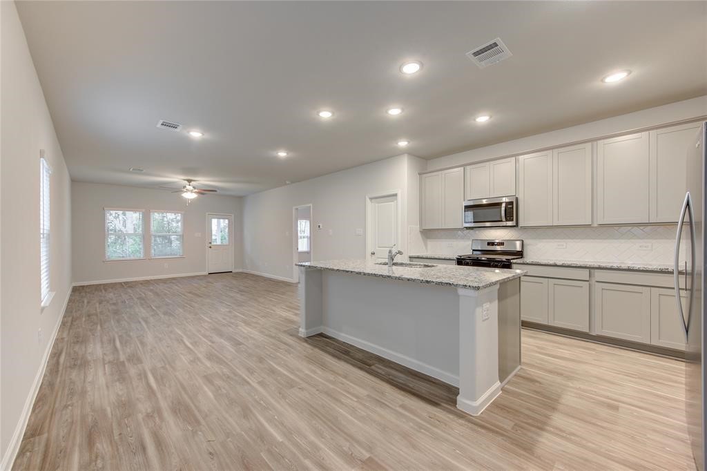 94 Valiant Ridge Trail Magnolia, TX 77354 - Photo 4 of 13 a kitchen with stainless steel appliances a refrigerator sink and microwave