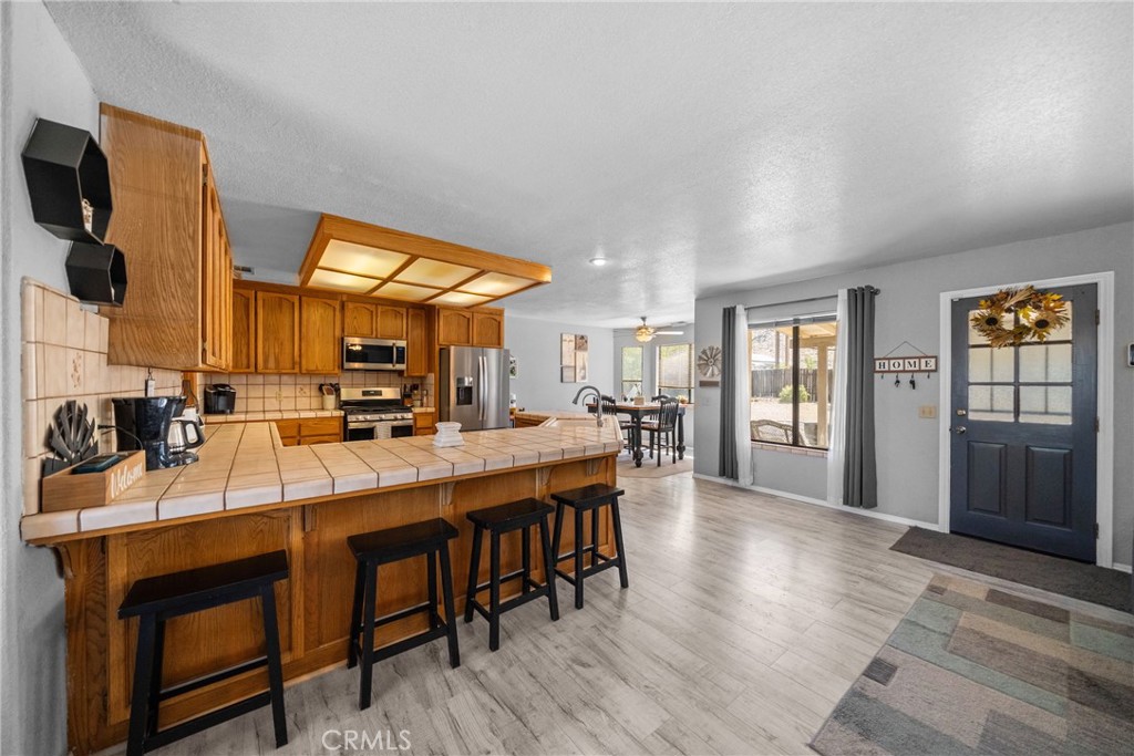 16161 St Timothy Road Apple Valley, CA 92307 - Photo 14 of 35 a room with stainless steel appliances kitchen island granite countertop a table chairs and a refrigerator