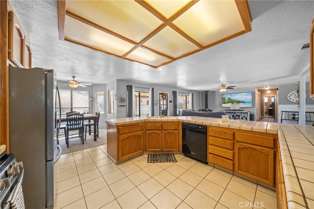 16161 St Timothy Road Apple Valley, CA 92307 - Photo 17 of 35 a kitchen with stainless steel appliances granite countertop a refrigerator and a stove top oven