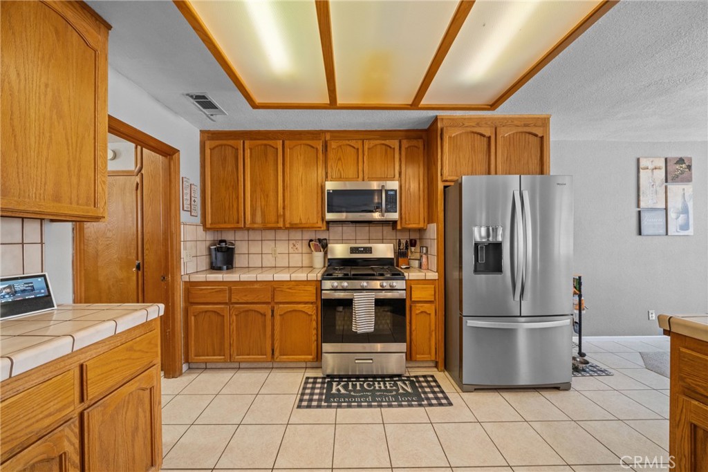 16161 St Timothy Road Apple Valley, CA 92307 - Photo 19 of 35 a kitchen with stainless steel appliances granite countertop a refrigerator stove and sink