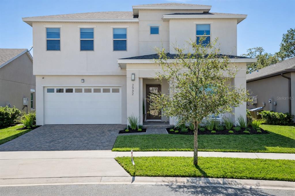 2932 Tupelo Loop St. Cloud, FL 34772 - Photo 1 of 47 a front view of a house with a garden and plants