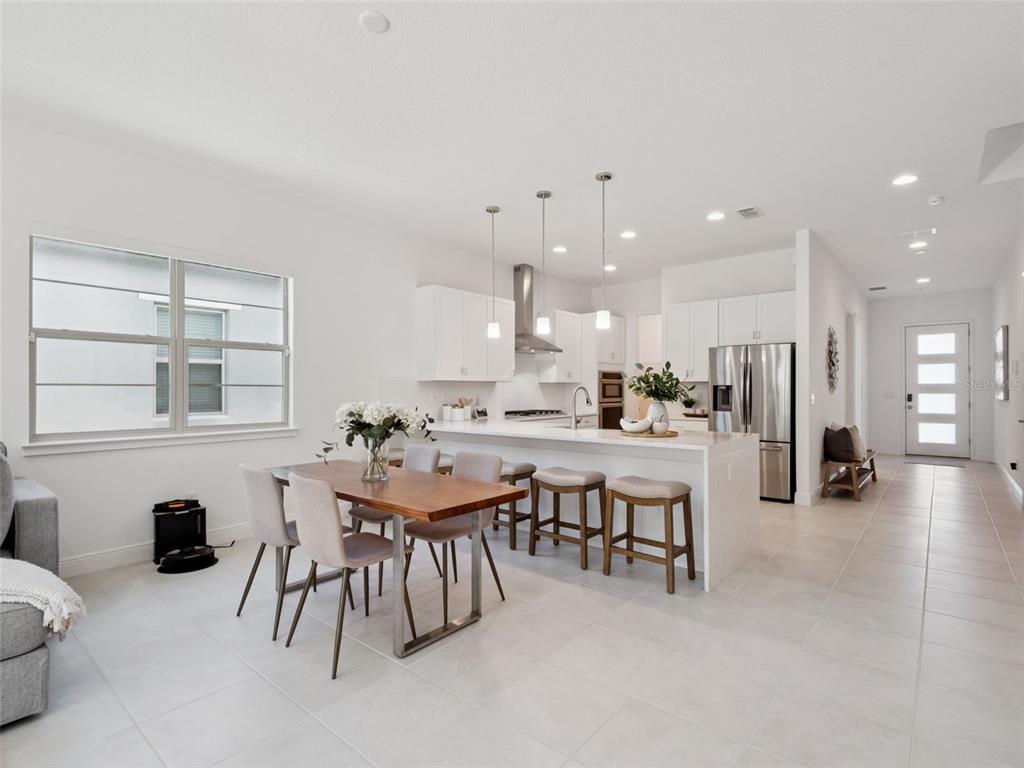 2932 Tupelo Loop St. Cloud, FL 34772 - Photo 18 of 47 a dining hall with stainless steel appliances kitchen island a table and chairs