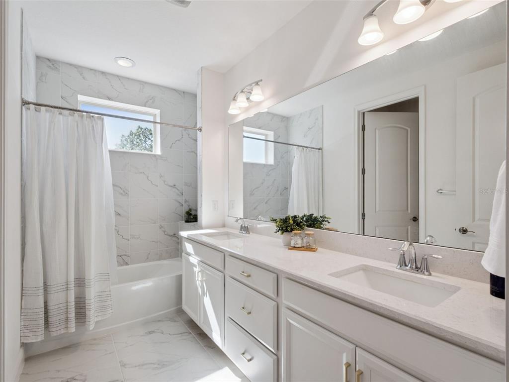 2932 Tupelo Loop St. Cloud, FL 34772 - Photo 22 of 47 a bathroom with a double vanity sink mirror double and bathtub