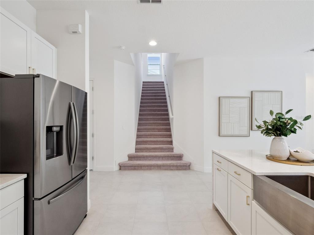 2932 Tupelo Loop St. Cloud, FL 34772 - Photo 24 of 47 a kitchen with white cabinets and white appliances