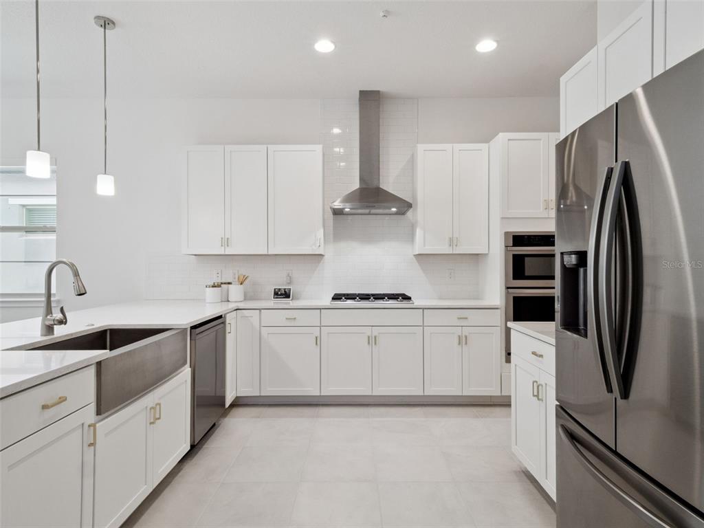 2932 Tupelo Loop St. Cloud, FL 34772 - Photo 7 of 47 a kitchen with stainless steel appliances granite countertop a refrigerator sink and stove