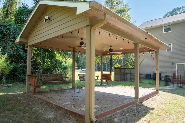 a view of a patio with table and chairs under an umbrella with a small yard