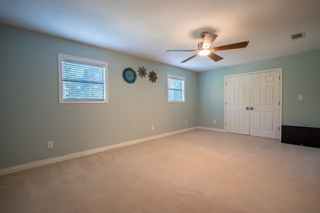 a bedroom with a bed and a ceiling fan