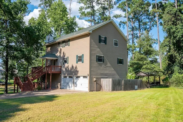 a view of a house with a yard and large tree