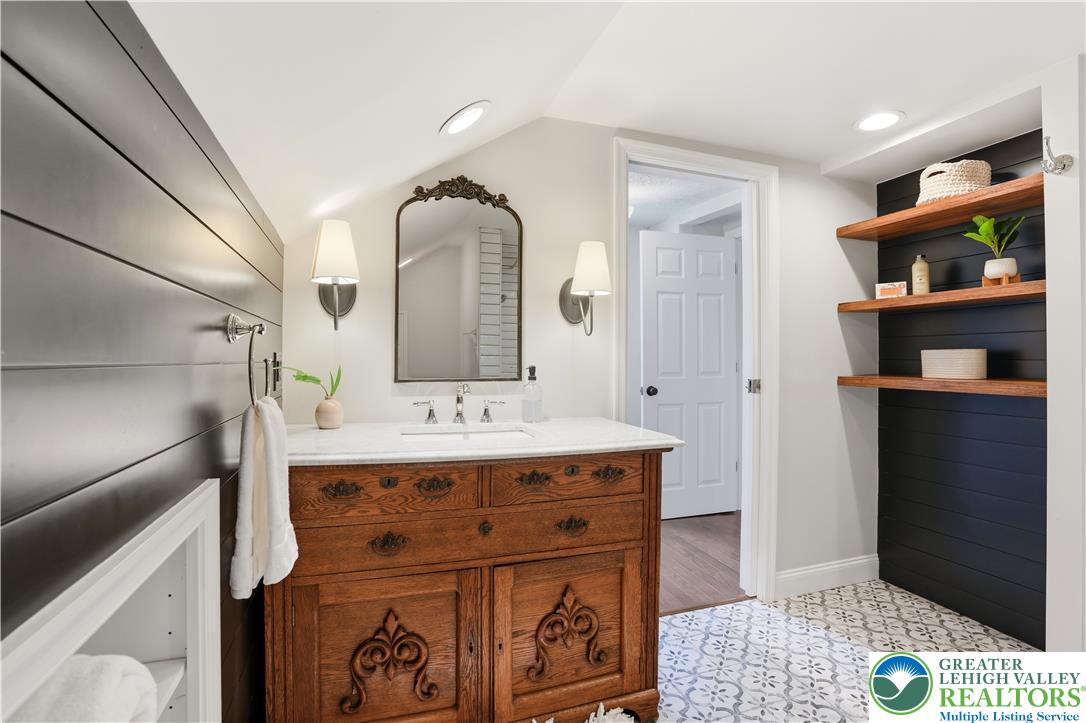 2014 Linden Street Bethlehem, PA 18017 - Photo 42 of 85 A well-lit bathroom showcases a beautiful wood vanity with a marble top and artistic floor tiling.