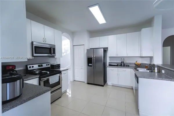 a kitchen with granite countertop a sink a stove and cabinets