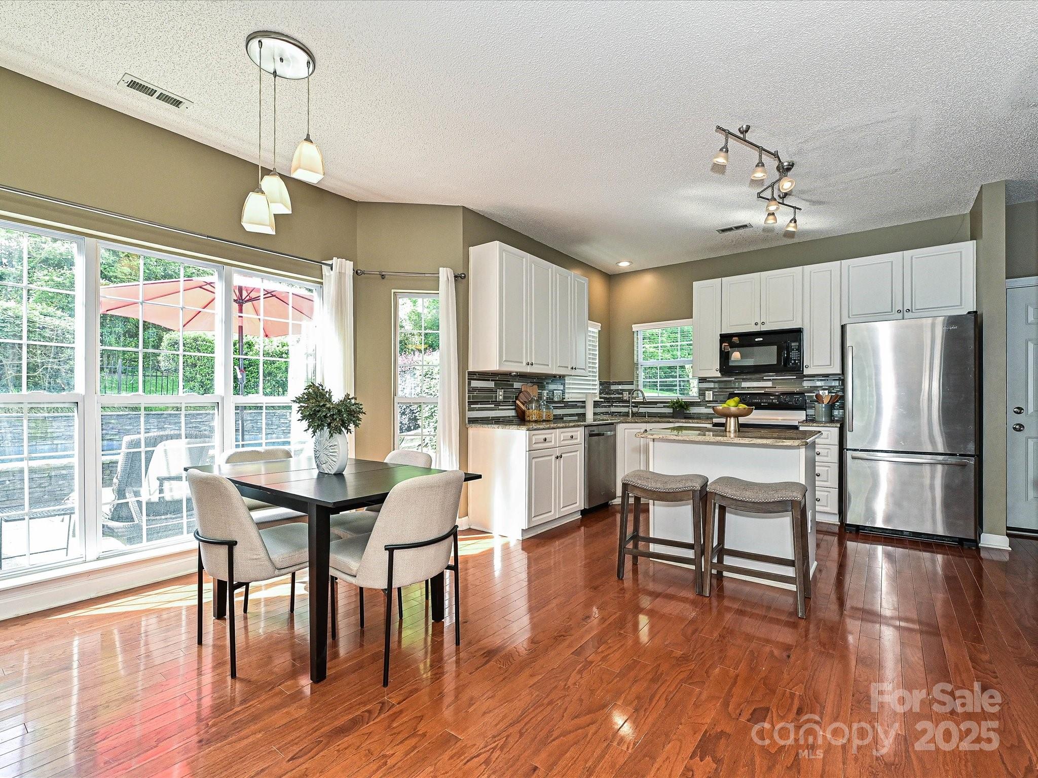 557 South Portman Lane Fort Mill, SC 29708 - Photo 14 of 29 a kitchen with stainless steel appliances a dining table chairs refrigerator and microwave