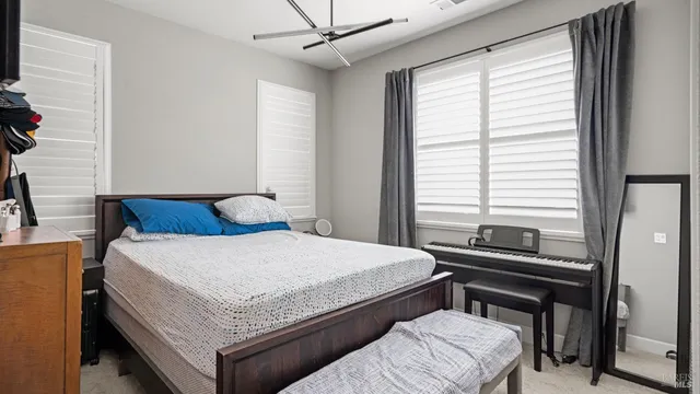 a bedroom with a bed and a dresser next to a window