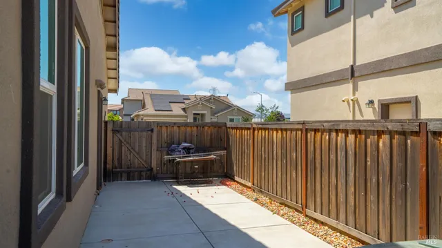 a view of a white house with large windows and a yard