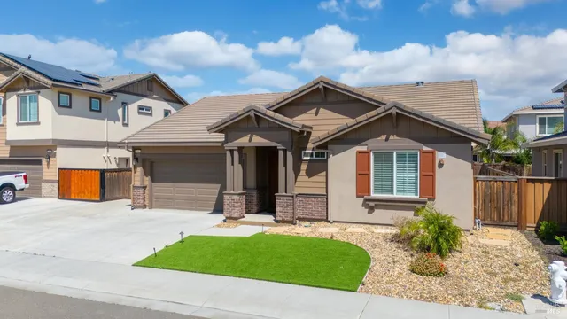a view of a white house with a small yard and plants