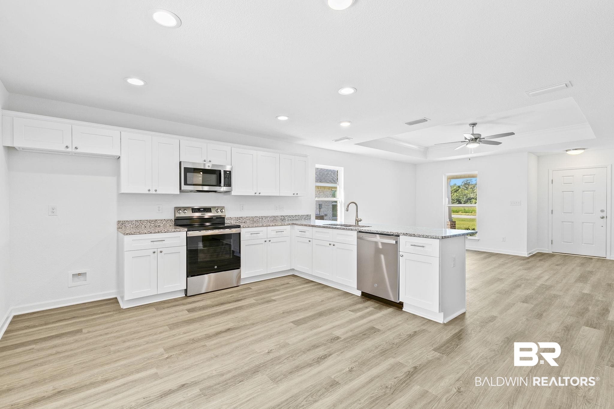 16014 Alabama Avenue Silverhill, AL 36576 - Photo 14 of 50 Kitchen with appliances with stainless steel finishes, light wood-type flooring, a tray ceiling, and white cabinetry