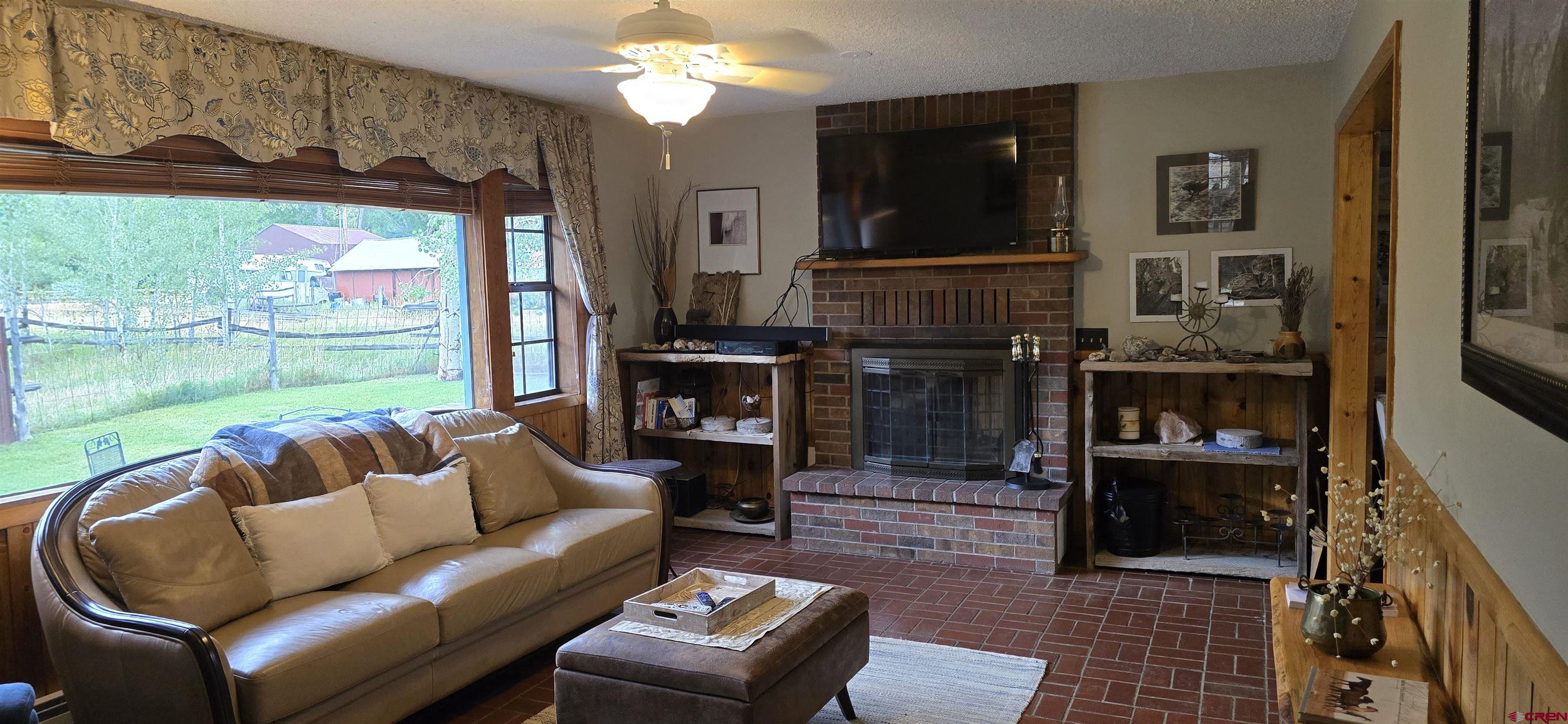 605 County Road 23 Ridgway, CO 81432 - Photo 8 of 26 a living room with furniture a lamp and a fireplace