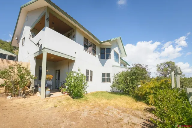 a view of a white house with a yard