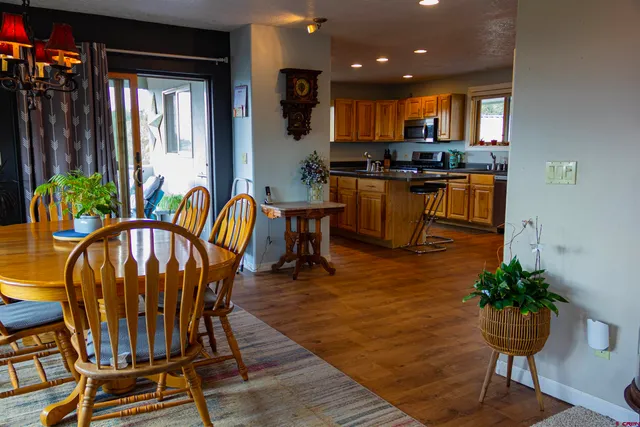 a kitchen with granite countertop lots of wooden furniture dining table and chairs
