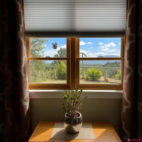 a vase of flowers sitting on a table with a window