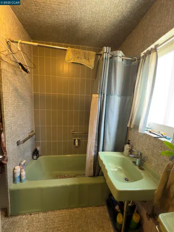 a bathroom with a sink a mirror a bathtub and shower