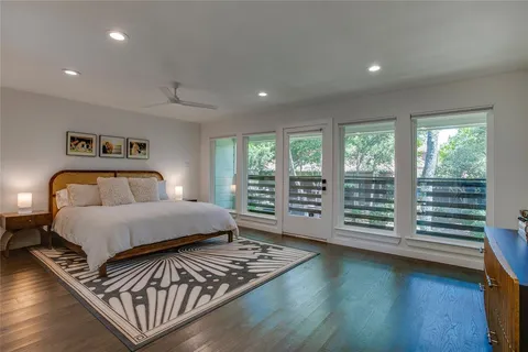 a bedroom with a bed a large window and walk in closet