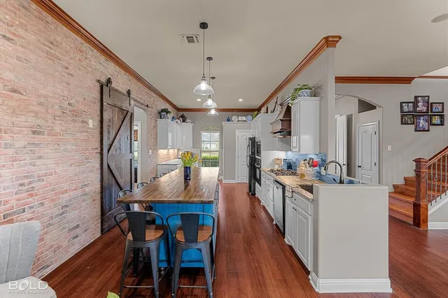 a very nice looking dining room with wooden floor and stairs