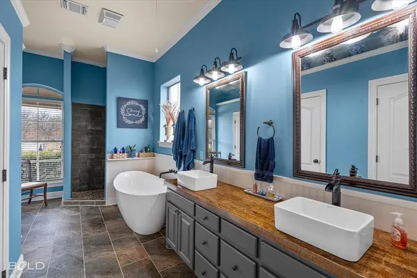 a spacious bathroom with a double vanity sink a mirror and a bathtub