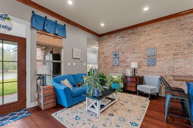 a living room with furniture wooden floor and a large window