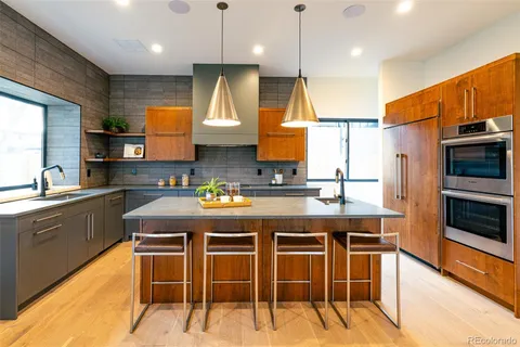 a kitchen with stainless steel appliances kitchen island granite countertop a table chairs sink and microwave