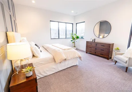 a bedroom with a bed mirror and a window