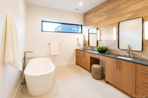 a bathroom with a tub sink and mirror