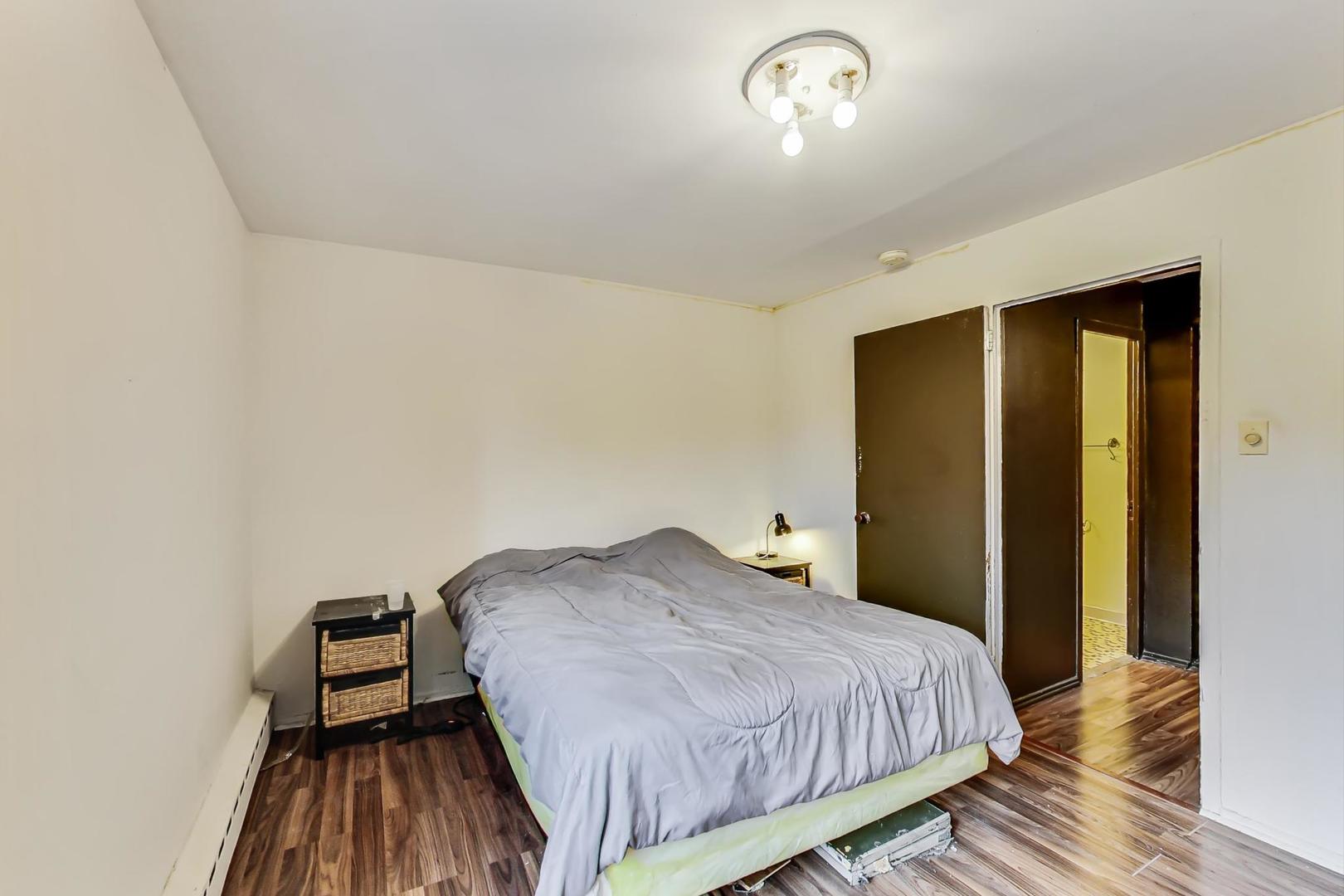 700 West Bittersweet Place, Unit 309 Chicago, IL 60613 - Photo 12 of 19 a bedroom with a bed and wooden floor