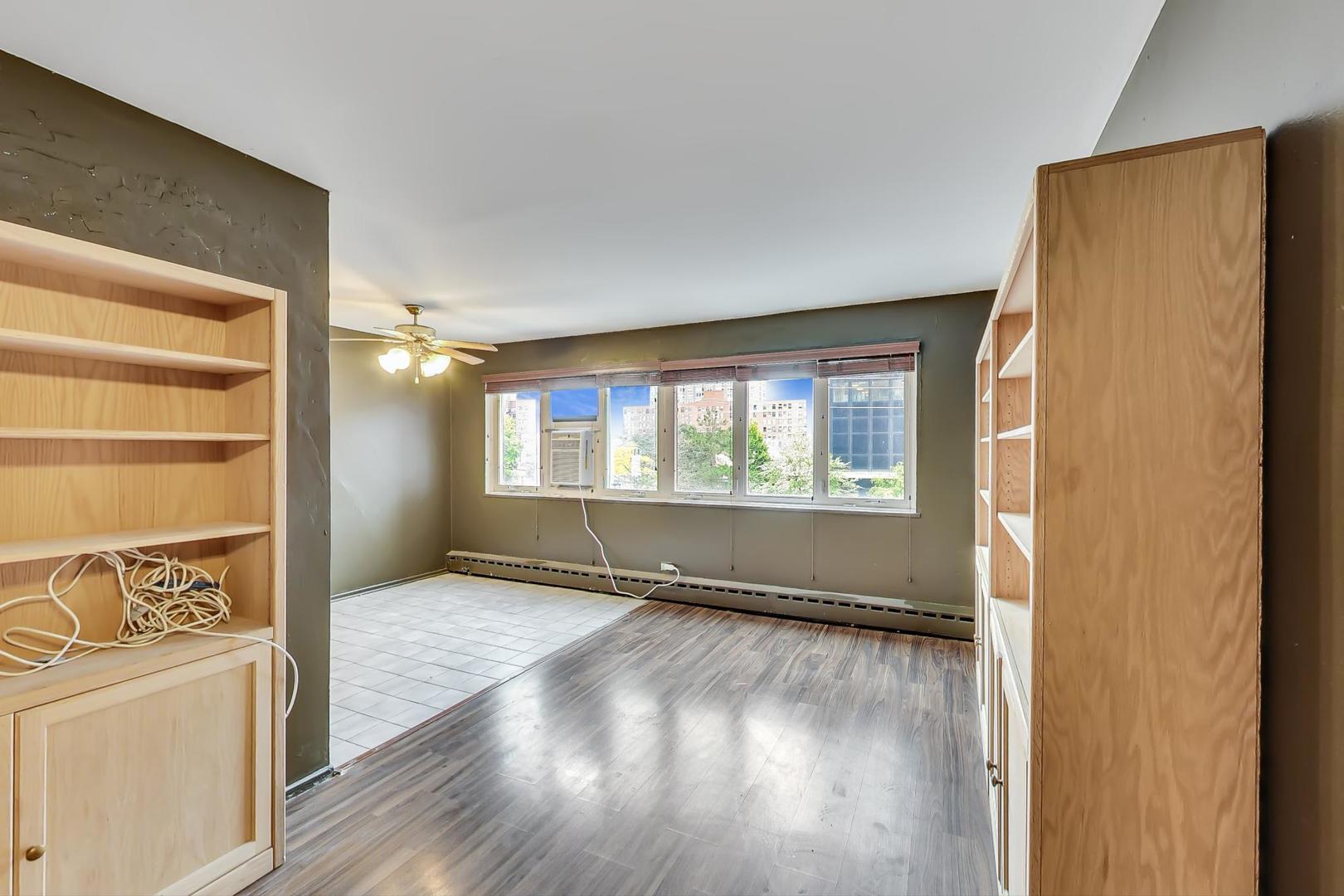 700 West Bittersweet Place, Unit 309 Chicago, IL 60613 - Photo 4 of 19 an empty room with wooden floor and windows