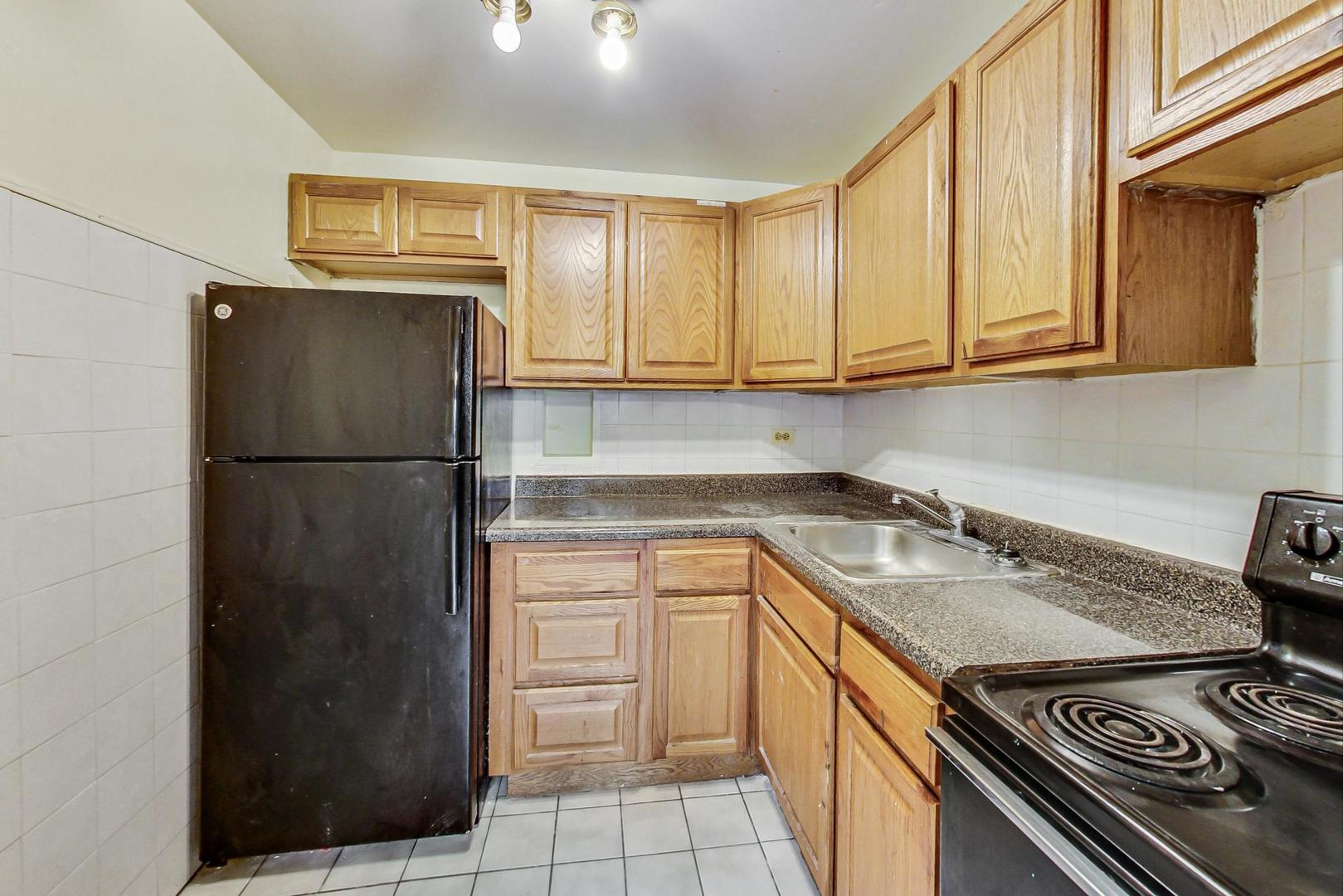 700 West Bittersweet Place, Unit 309 Chicago, IL 60613 - Photo 8 of 19 a kitchen with a sink stove and refrigerator