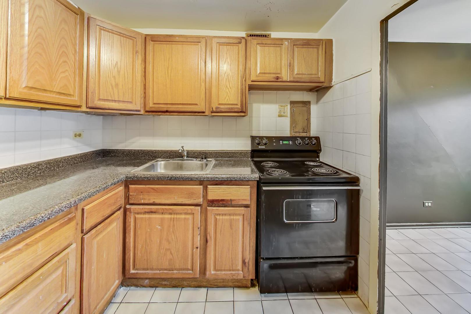 700 West Bittersweet Place, Unit 309 Chicago, IL 60613 - Photo 9 of 19 a kitchen with granite countertop white cabinets and stainless steel appliances