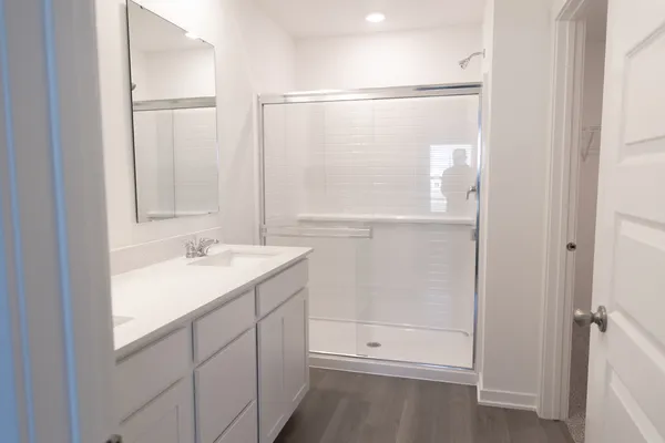 a bathroom with a shower sink and mirror