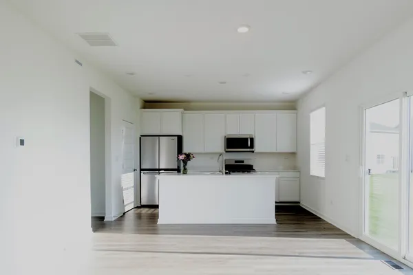 a view of a kitchen with stainless steel appliances a sink and a refrigerator