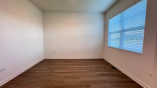 a view of a room with wooden floor and a window